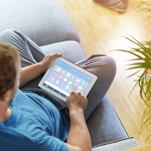 Man using a home automation app on a tablet device