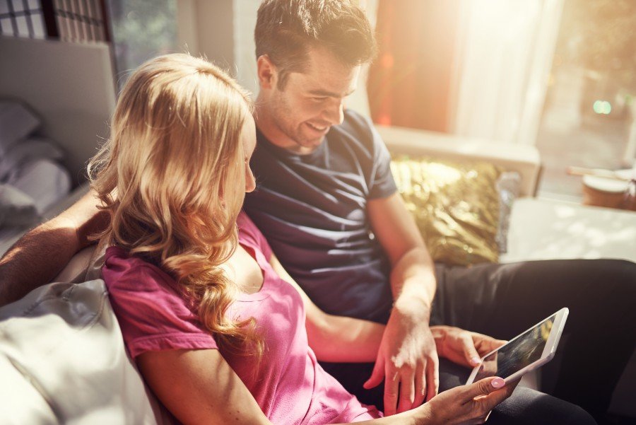 attractive couple using tablet together o nfuton h at home